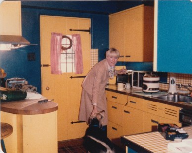 My mother in the yellow kitchen with Muffin.